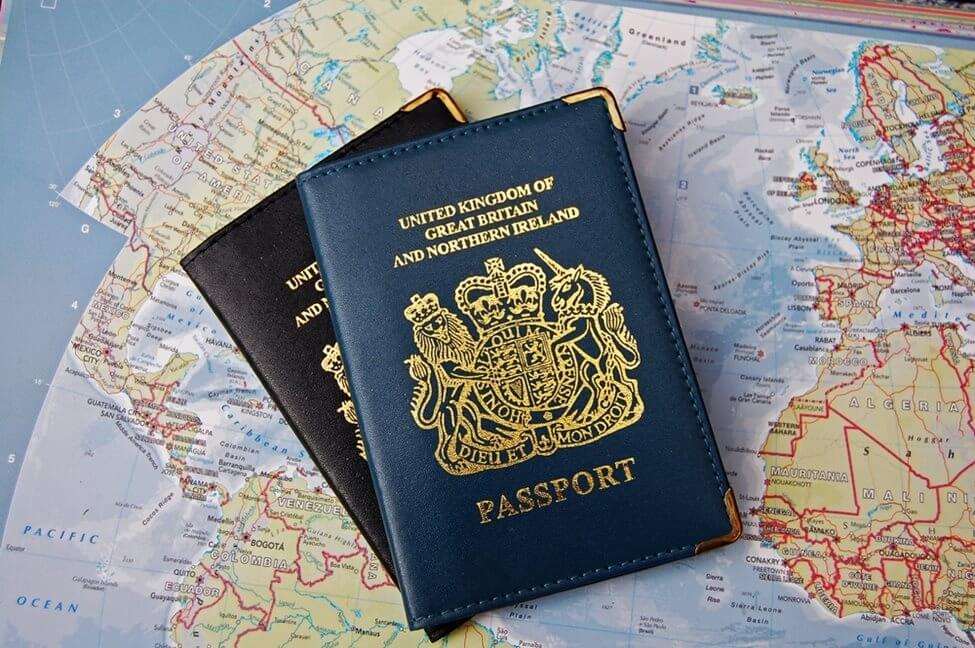 Two new UK passports, overlapping over a map of the world.