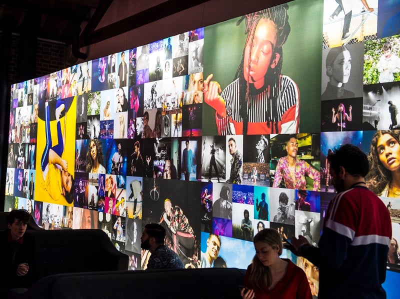 Photographs of various young artists displayed on a photo wall at the event BBC Introducing