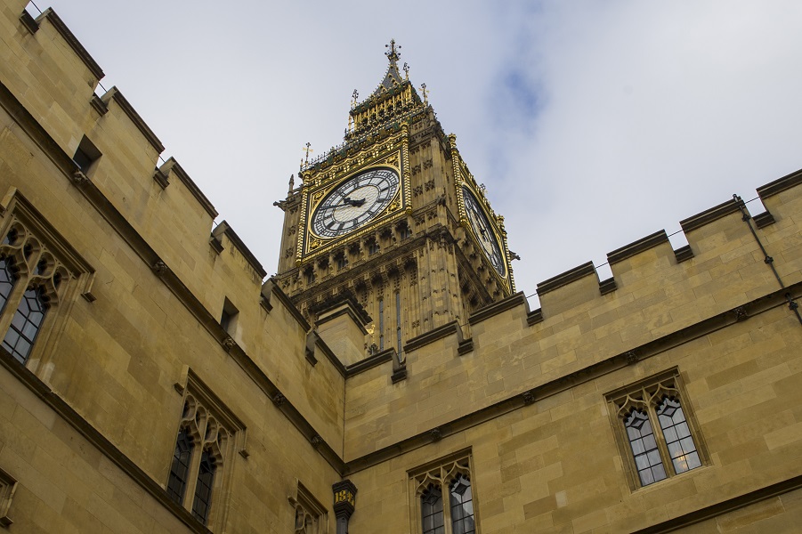 Photograph of Big Ben, a below photo showing just the clock face angled against a cloudy sky.
