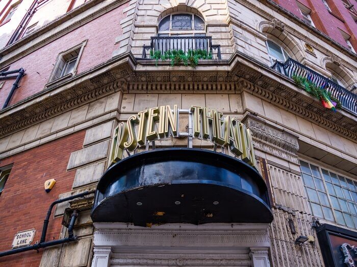 Close up of The Epstein Theatre sign in large gold lettering outside the venue in daytime.