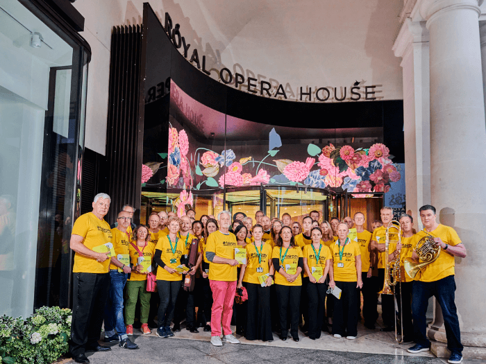 The Royal Opera House orchestra wearing yellow FairPay t-shirts outside of the entrance to the building.