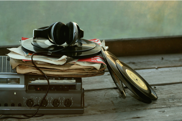 Photograph of a record player, stack of records with earphones on top.
