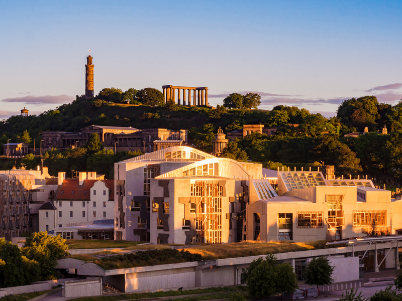 The sun is setting over the Scottish Parliament buildings as they stand in Holyrood, Edinburgh.