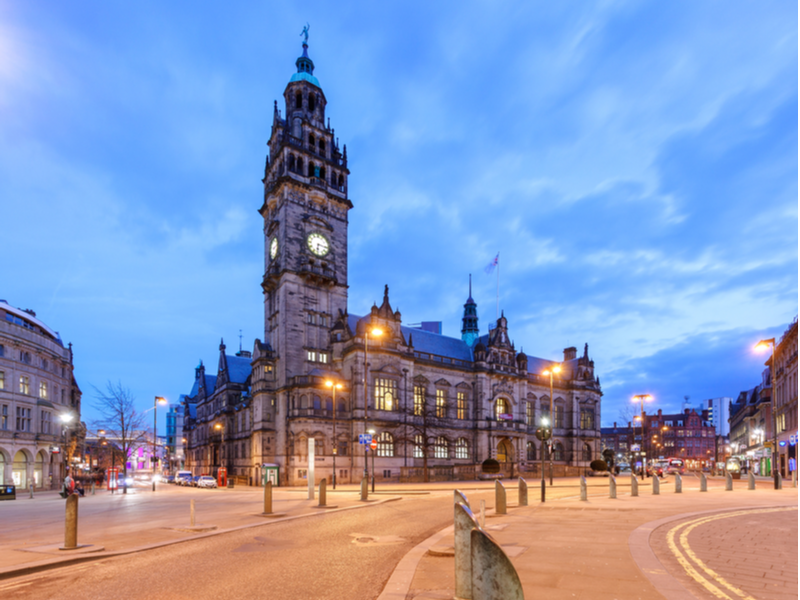 Photograph of Sheffield town hall, taken at dusk the sky is darkening and the street lights have just turned on.