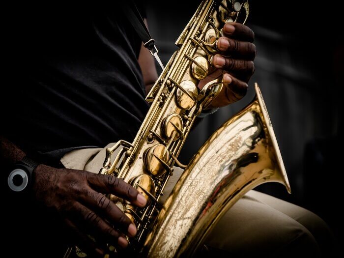 A close up of a Black musician holding a saxophone.