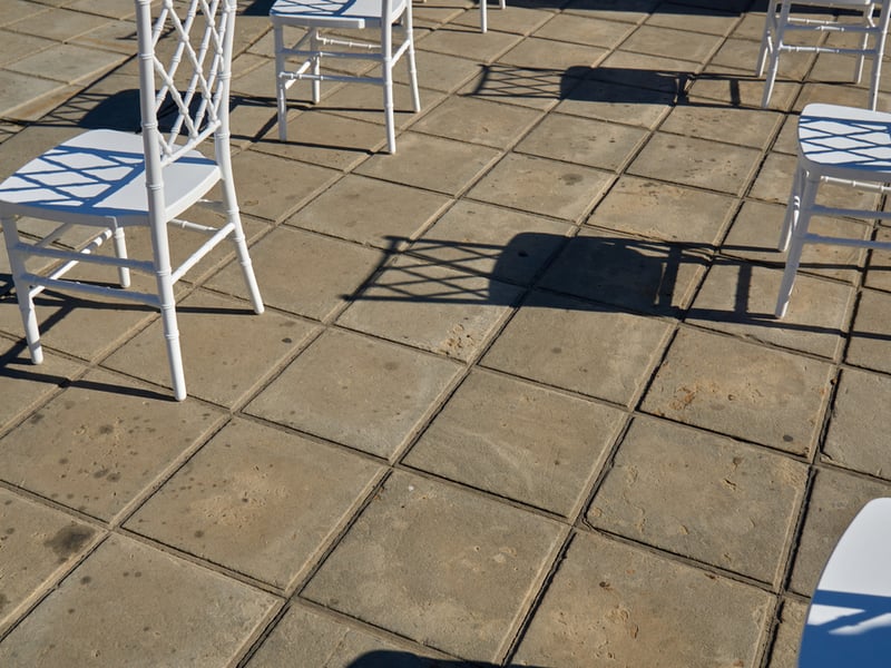 Photograph of white chairs in an outdoor setting, set out with socially distanced space around each one.